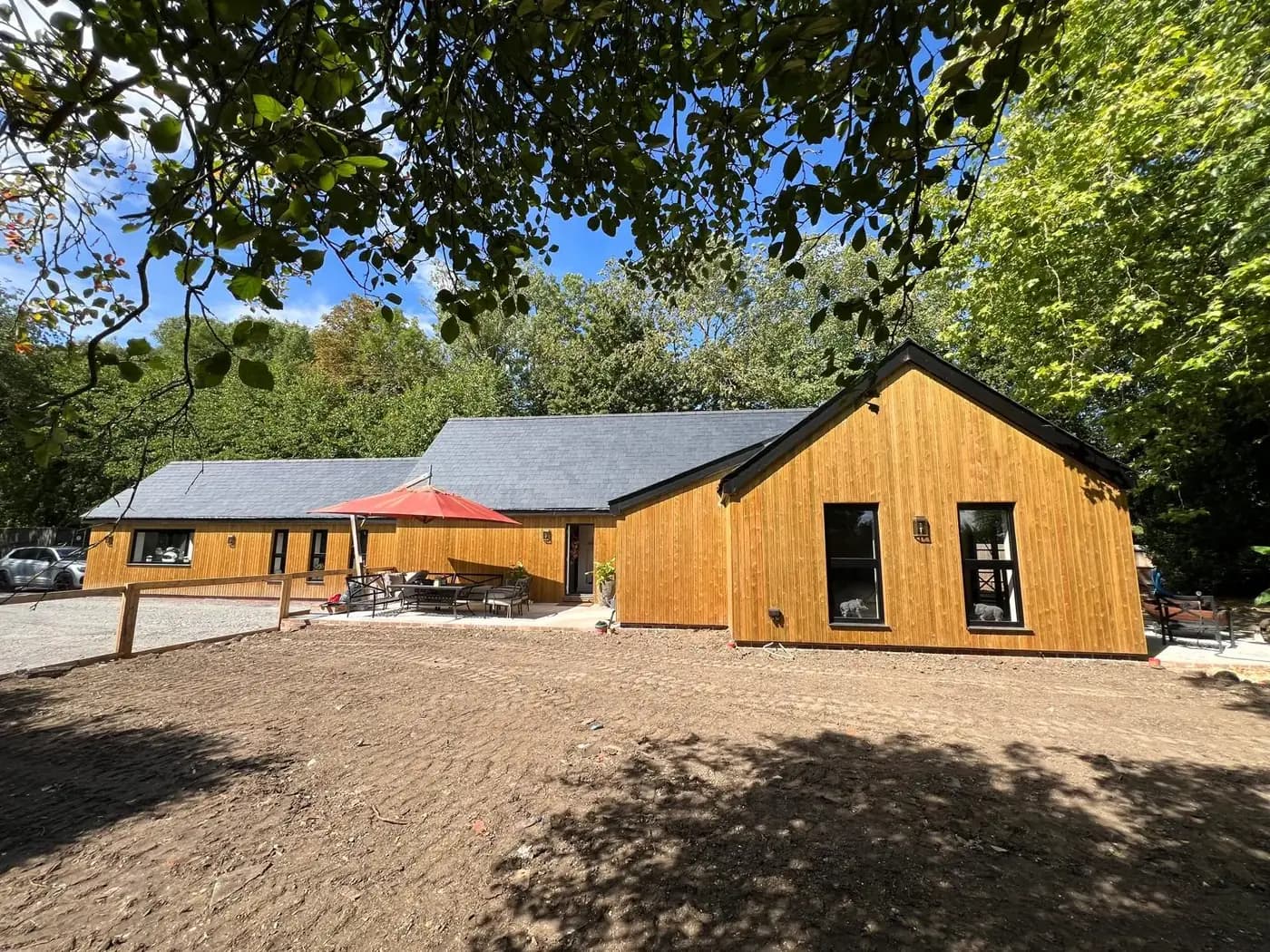 Timber-clad countryside extension with a slate roof, typical of a proportionate Green Belt addition
